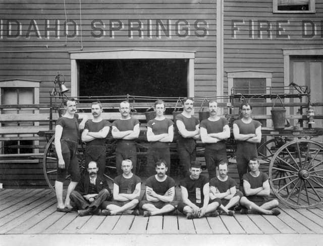 Historic 1895 Idaho Springs Fire Department firefighters posing outside station with antique fire wagon and equipment in Idaho Springs, Colorado Historic 1895 Idaho Springs Fire Department firefighters posing outside station with antique fire wagon and equipment in Idaho Springs, Colorado